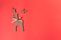 Broken wooden deer decoration on red background. Christmas and New Year decoration. Repair and recovery concept. Top view, copy