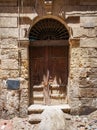 Broken wooden door on grunge stone bricks wall in abandoned district Royalty Free Stock Photo