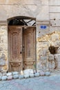 Broken wooden door on grunge stone bricks wall in abandoned street Royalty Free Stock Photo