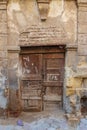 Broken wooden door on grunge stone bricks wall in abandoned street Royalty Free Stock Photo