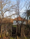 a broken wooden fence in front of an old, abandoned house