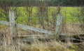 A broken wooden fence by a pubic path