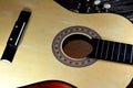 A broken wooden old classic guitar with damaged strings chords, shattered musical instrument, unattached damaged guitar with cut