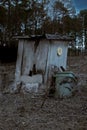 Broken wooden toilet in a wooded area