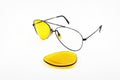 Broken yellow sunglasses lens on white background