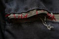 Broken zipper on a backpack sewn in red thread Royalty Free Stock Photo