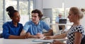 Broker making presentation to diverse young couple showing them document Royalty Free Stock Photo