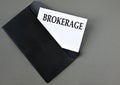 BROKERAGE - word on white paper on a black envelope with a magnifying glass Royalty Free Stock Photo
