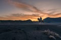 Tengger man with his horse posing on the black sand savanna of Mt Bromo during a beautiful sunrise