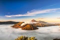 Bromo volcano crater erupt release smoke with sunrise sky background and morning fog landscape at Indonesia Bromo national park Royalty Free Stock Photo