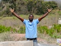 Unidentified Ghanaian man in blue shirt raises his hands and li