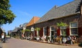 View on old typical cafe restaurant with people sitting outside against blue summer sky in small dutch village near river ijssel