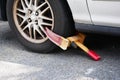 Car tire boot security lock close up on street. Old, rusted and dirty