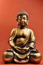 Bronze Buddha Statue Against Red Orange Background Royalty Free Stock Photo