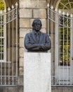 Bronze bust of a man with glasses and a coat and tie outside the historic Hospital de Santo Antonio in Porto, Portugal.