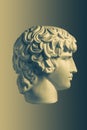 Bronze color gypsum copy ancient statue Antinous head lover of Roman Emperor Hadrian for artists on brass background Royalty Free Stock Photo