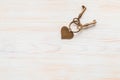 Bronze color keys and heart hitched on ring on wooden board. Space for text Royalty Free Stock Photo