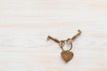 Bronze color keys and heart together lying on wooden board. Space for text Royalty Free Stock Photo