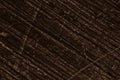 Bronze colored aged surface with dark diagonal stripes and scratches