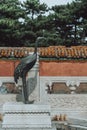 Bronze crane on white marble platform