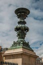 Bronze decoration on marble pedestal with cloudy sky in Paris. Royalty Free Stock Photo