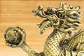 Bronze dragon. Gold statuette on a wooden background