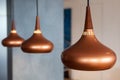 Bronze hanging dining lights combination with cool grey background.