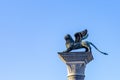 Bronze lion on the Piazza San Marco on blue sky background, Venice, Italy. Winged lion is a symbol of Venice. Ancient statue on a Royalty Free Stock Photo