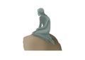 A bronze little Mermaid statue sitting on the rock