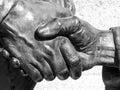 Bronze meeting shaking hands, fragment of a statue. Royalty Free Stock Photo