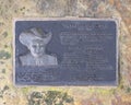 A bronze memorial plaque attached to a rock in front of the gazebo on the east side of the historic town square.