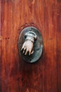 Bronze metal decoration in hand shape on an old medieval wooden door Royalty Free Stock Photo