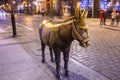 Bronze monument of the donkey in the street of Torun at night, Poland