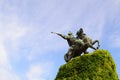 A bronze monument on a pedestal, a rider on a horse.