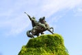 A bronze monument on a pedestal, a rider on a horse.