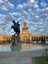 Bronze Sasuntsi David statue in front of a large building subway against a clouded sky