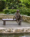 Bronze sculpture of a boy on a bench fishing by Gary Price at the Dallas Arboretum and Botanical Garden