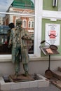 Bronze sculpture of an elderly man with glasses in the historical center of Omsk in summer