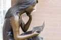 bronze sculpture of a girl lying on a bench reading a book in the P.P. Bazhova on a summer day