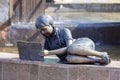 bronze sculpture of a girl lying on a bench reading a book in the P.P. Bazhova on a summer day