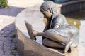 bronze sculpture of a girl lying on a bench reading a book in the P.P. Bazhova on a summer day