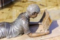 Bronze sculpture of a girl lying on a bench reading a book in the P.P. Bazhova on a summer day