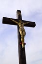 Bronze sculpture of Jesus Hristos crucified on a wooden cross. Royalty Free Stock Photo