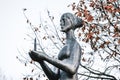 Bronze sculpture of mournful woman holding burning candle