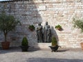 Bronze sculpture of St. Francis of Assisi and St. Clara on the square of the New Church in the medieval town of Assisi. Italy, Aug