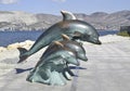 The bronze sculpture of three dolphins on the beach