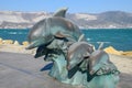 The bronze sculpture of three dolphins on the beach