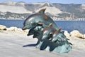 The bronze sculpture of three dolphins on the beach