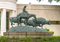 Bronze sculpture by unidentified artist featuring a cowboy on a horse herding cattle. Royalty Free Stock Photo