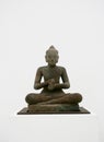 Bronze statue of a buddha kneeling in a meditative pose against a white background Royalty Free Stock Photo
